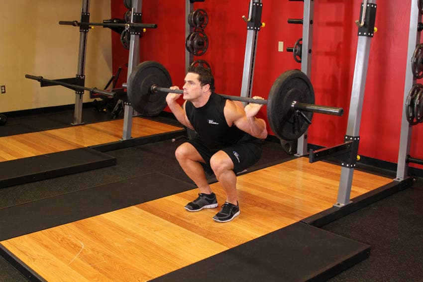 Démonstration de l’exercice : Squat à la barre, pieds serrés