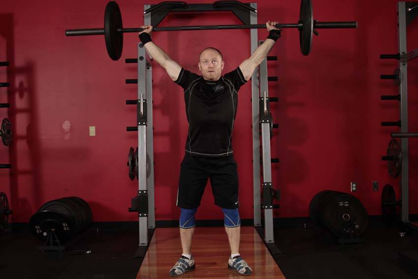 Démonstration de l’exercice : Squat avec barre au-dessus de la tête