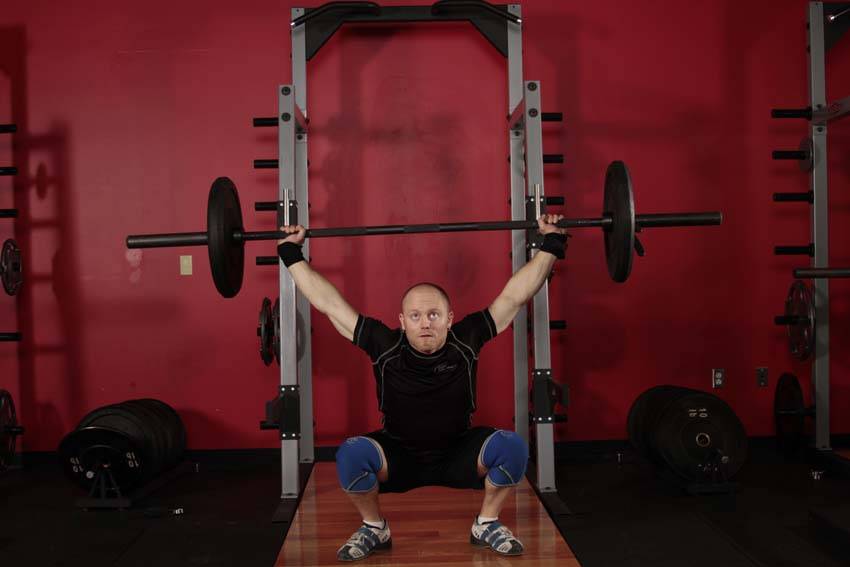 Démonstration de l’exercice : Squat avec barre au-dessus de la tête