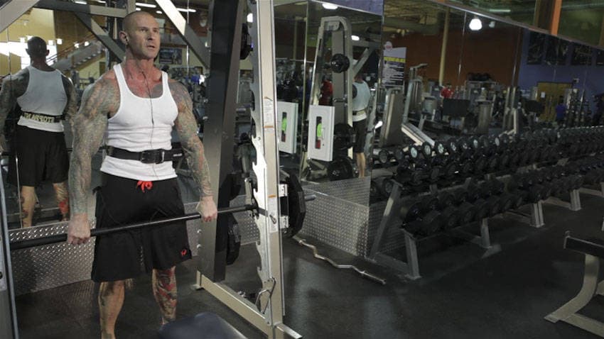 Démonstration de l’exercice : Épaulé suspendu à la Smith machine